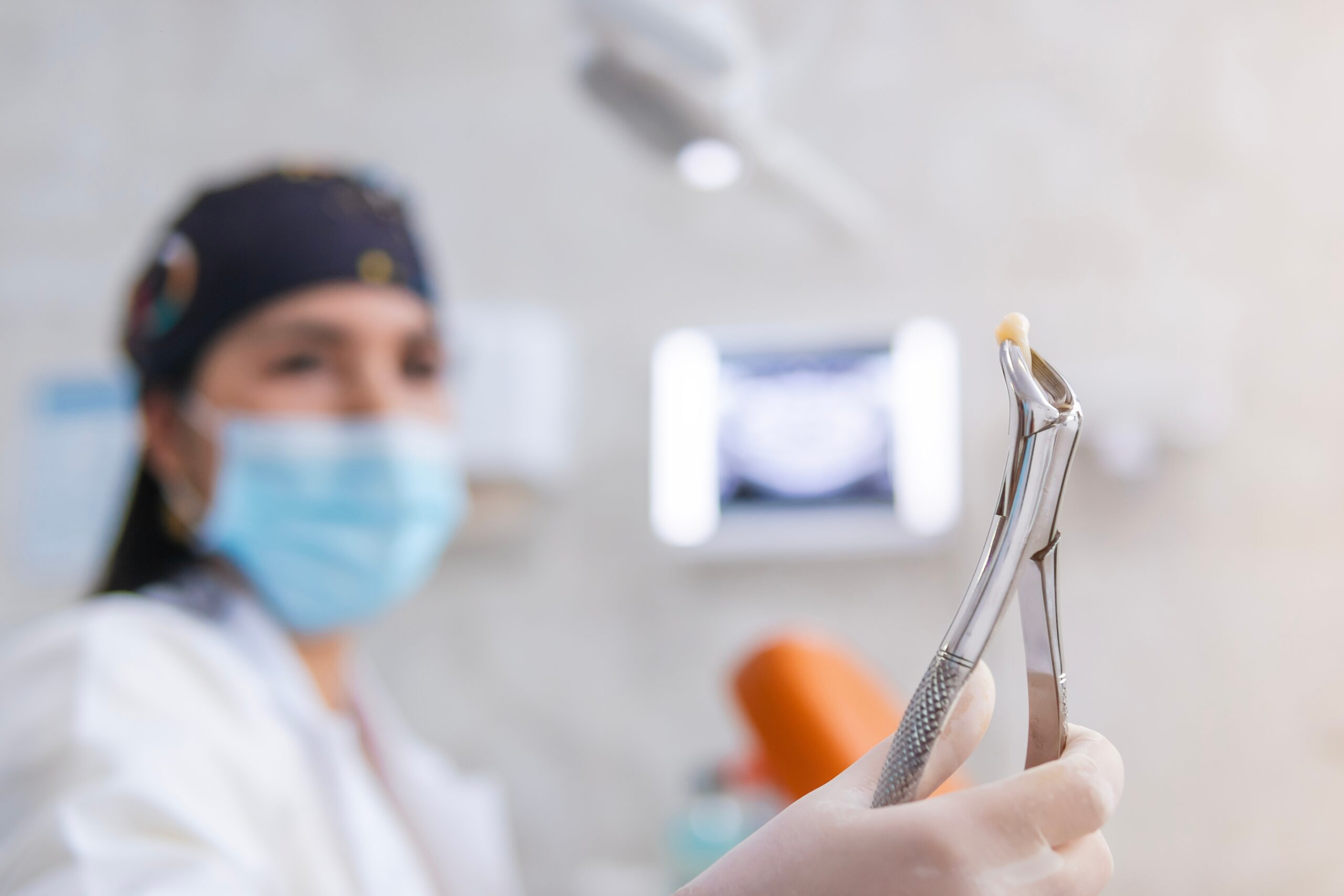 doctor holding up a tooth after an extraction