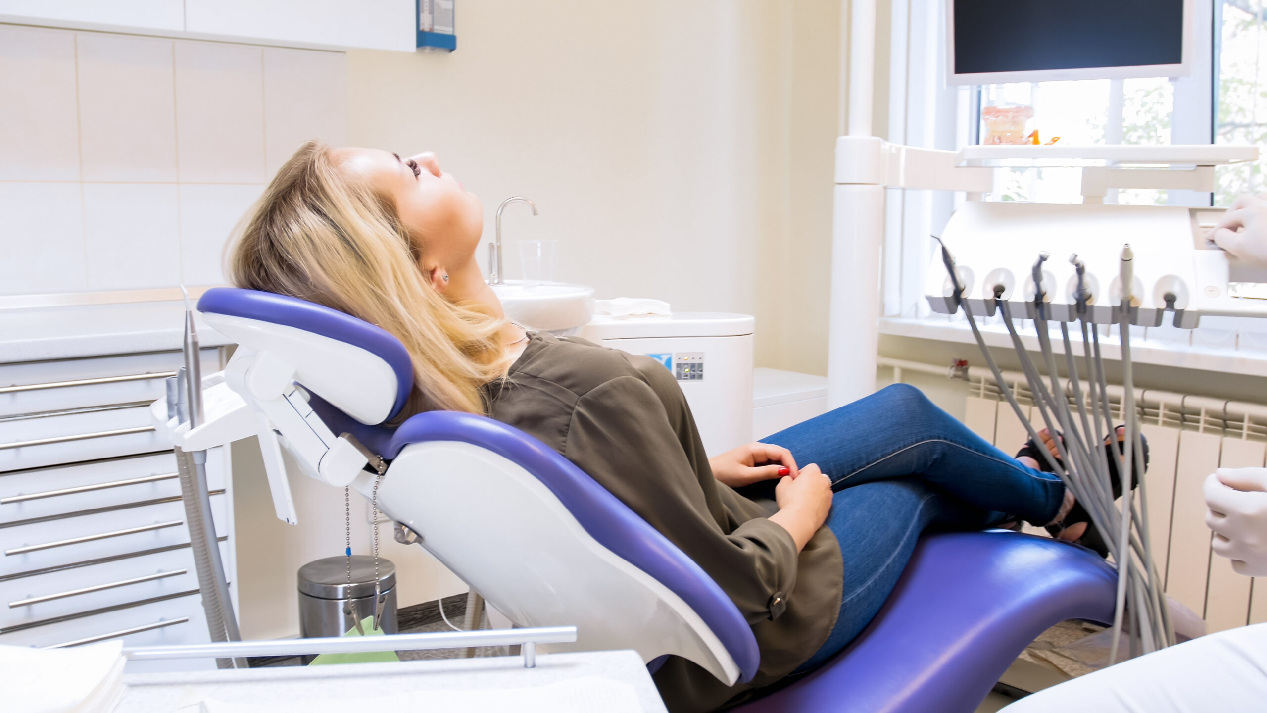 calm woman lying in dentist chair and waiting for doctor